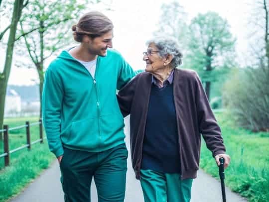 Eine Alltagsfee hilft einem Senior beim Spaziergang in Viersen.